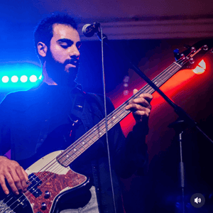 person performing live on stage with a bass guitar