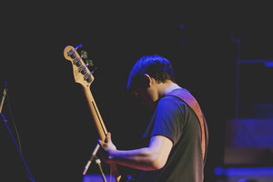 person playing bass guitar on stage