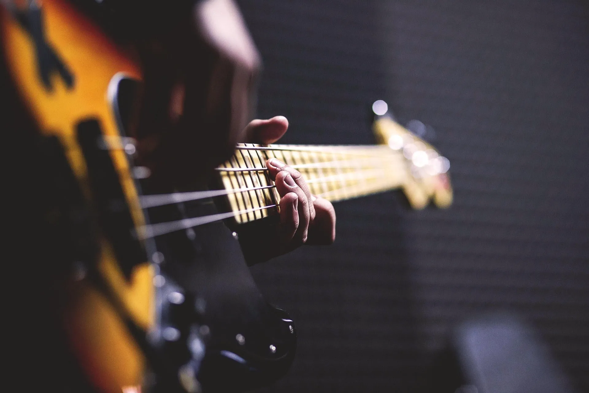 Hands learning a bass guitar line in a music studio